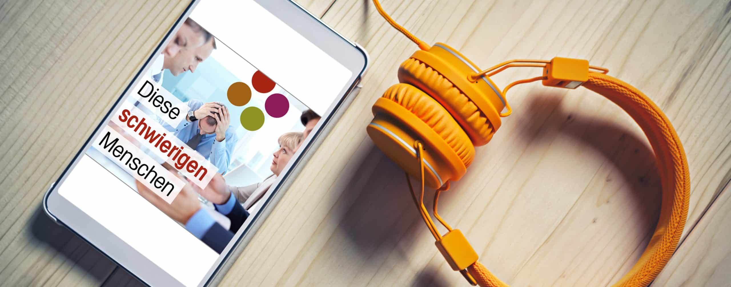 Handy mit Podcast Diese schwierigen Menschen und orangene Kopfhörer
